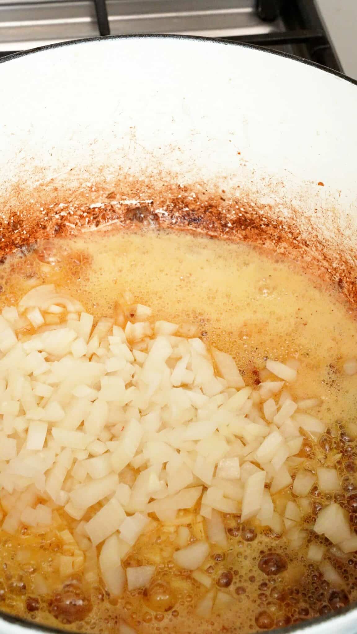 Onions and garlic simmering in butter in a pot.