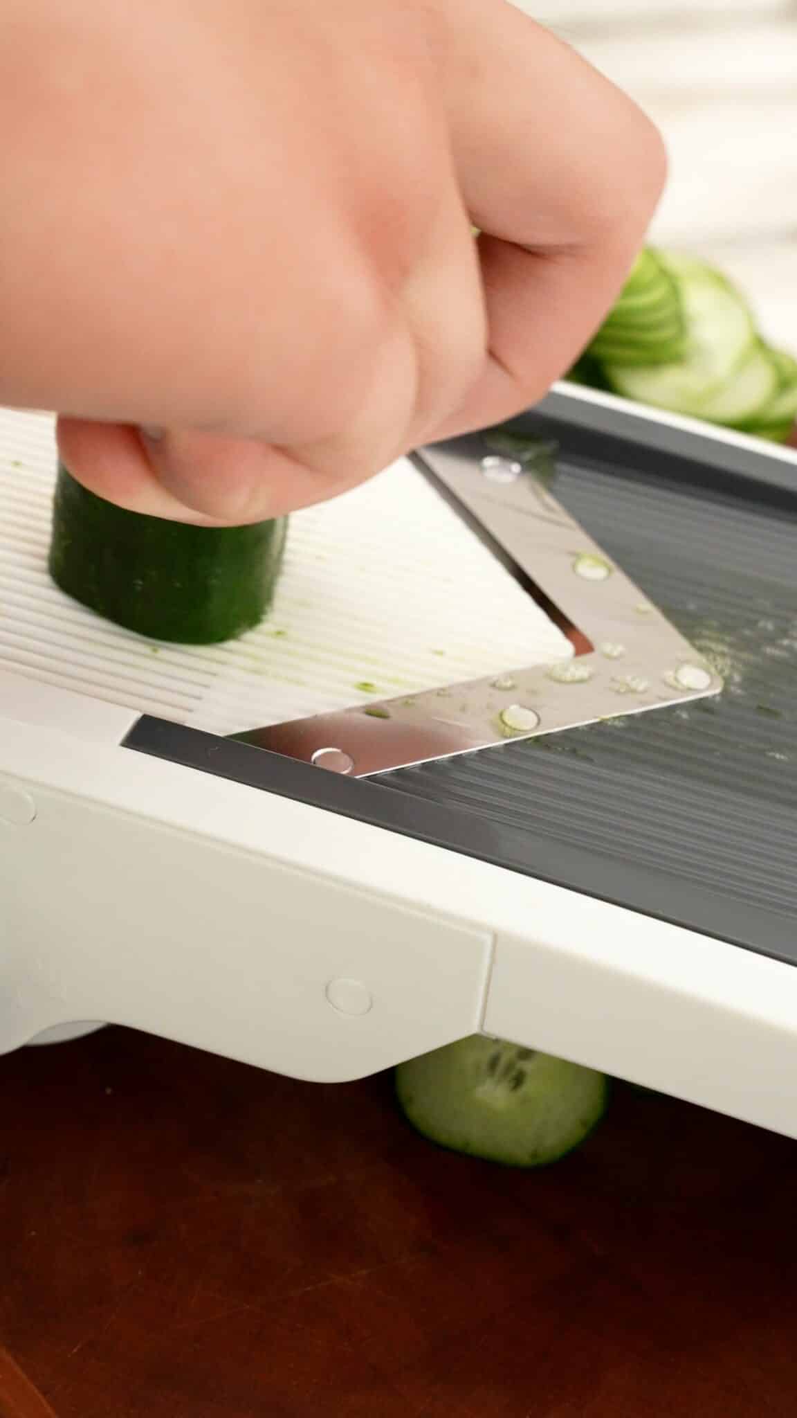 Thinly slicing cucumbers on a mandolin for Japanese Cucumber Salad.