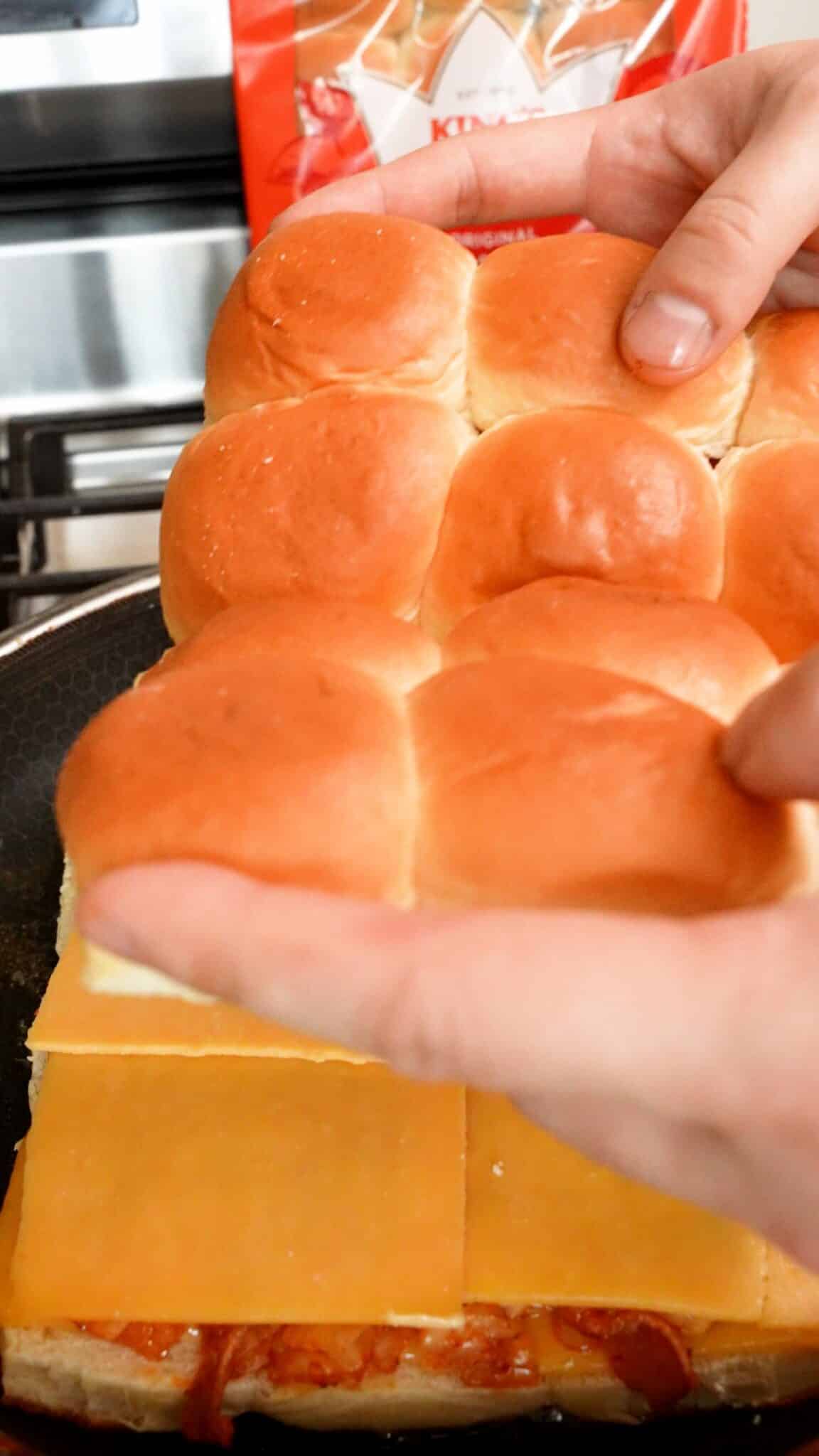 Assembling the Kimchi Grilled Cheese sliders in a pan.