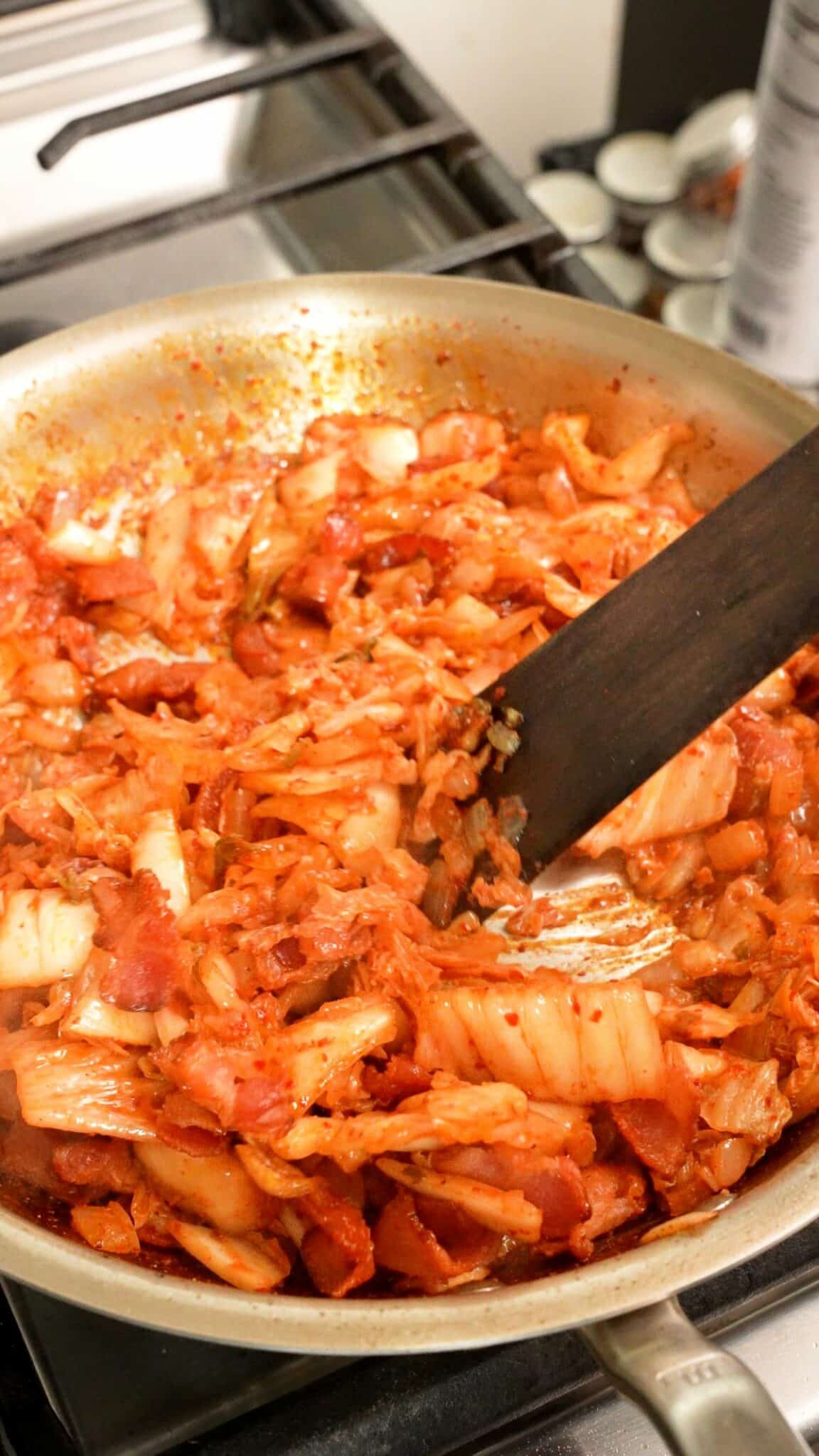 Kimchi, onion, and bacon cooked in a pan for Kimchi Grilled Cheese Sliders.