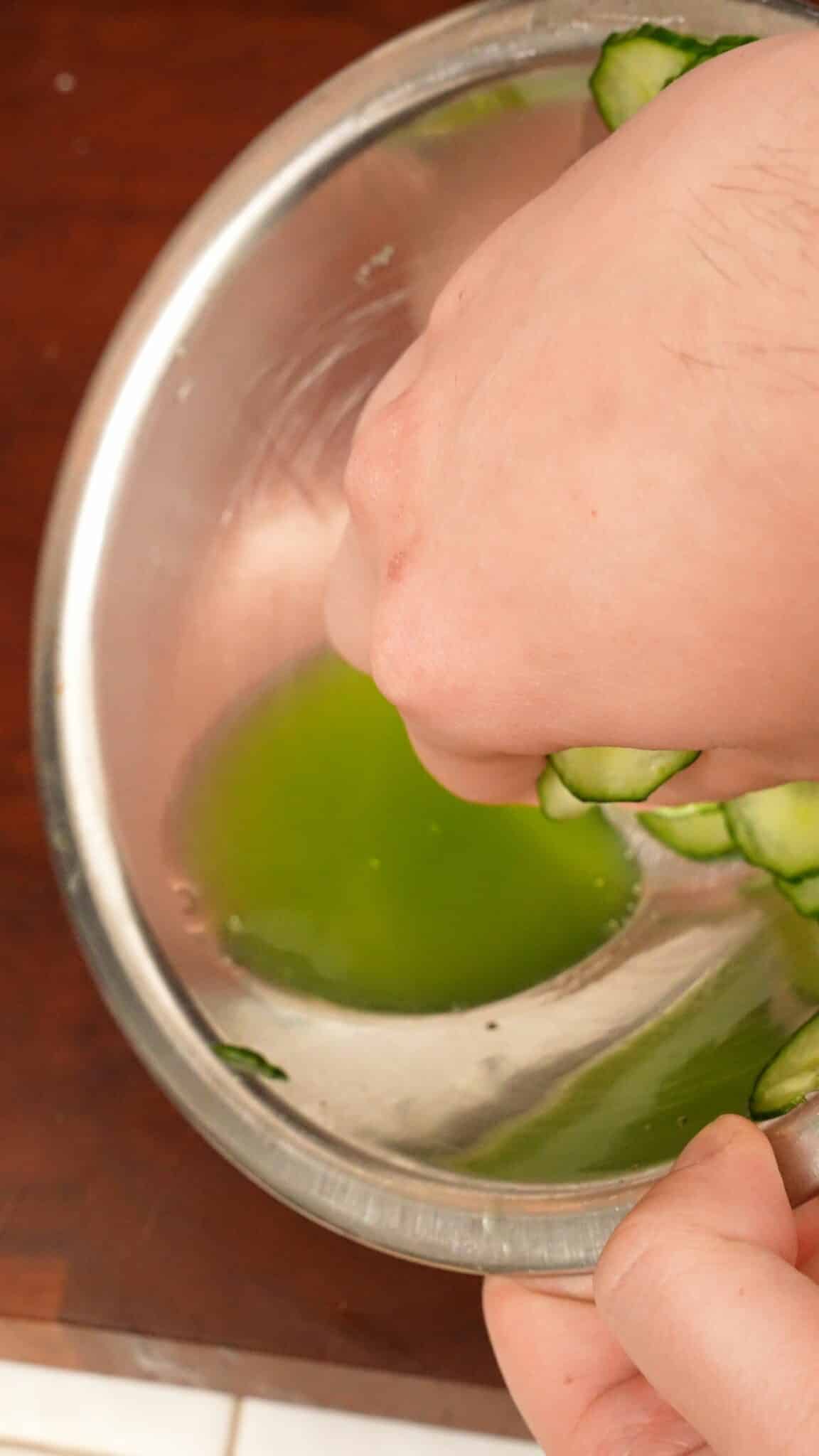 Draining water from cucumbers in a bowl.