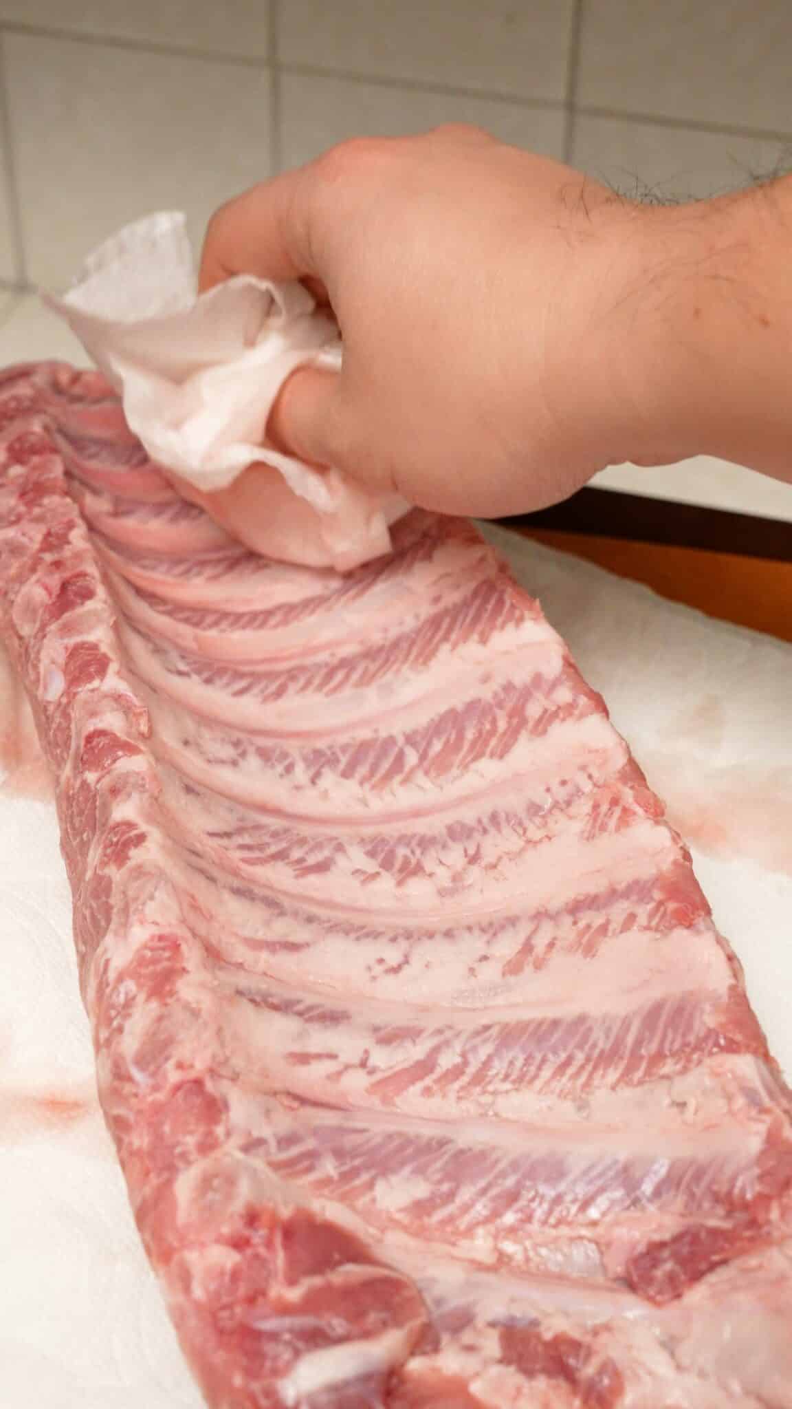 Patting ribs dry with a paper towel.