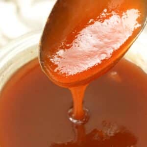 Sweet and sour sauce being spooned in a bowl.