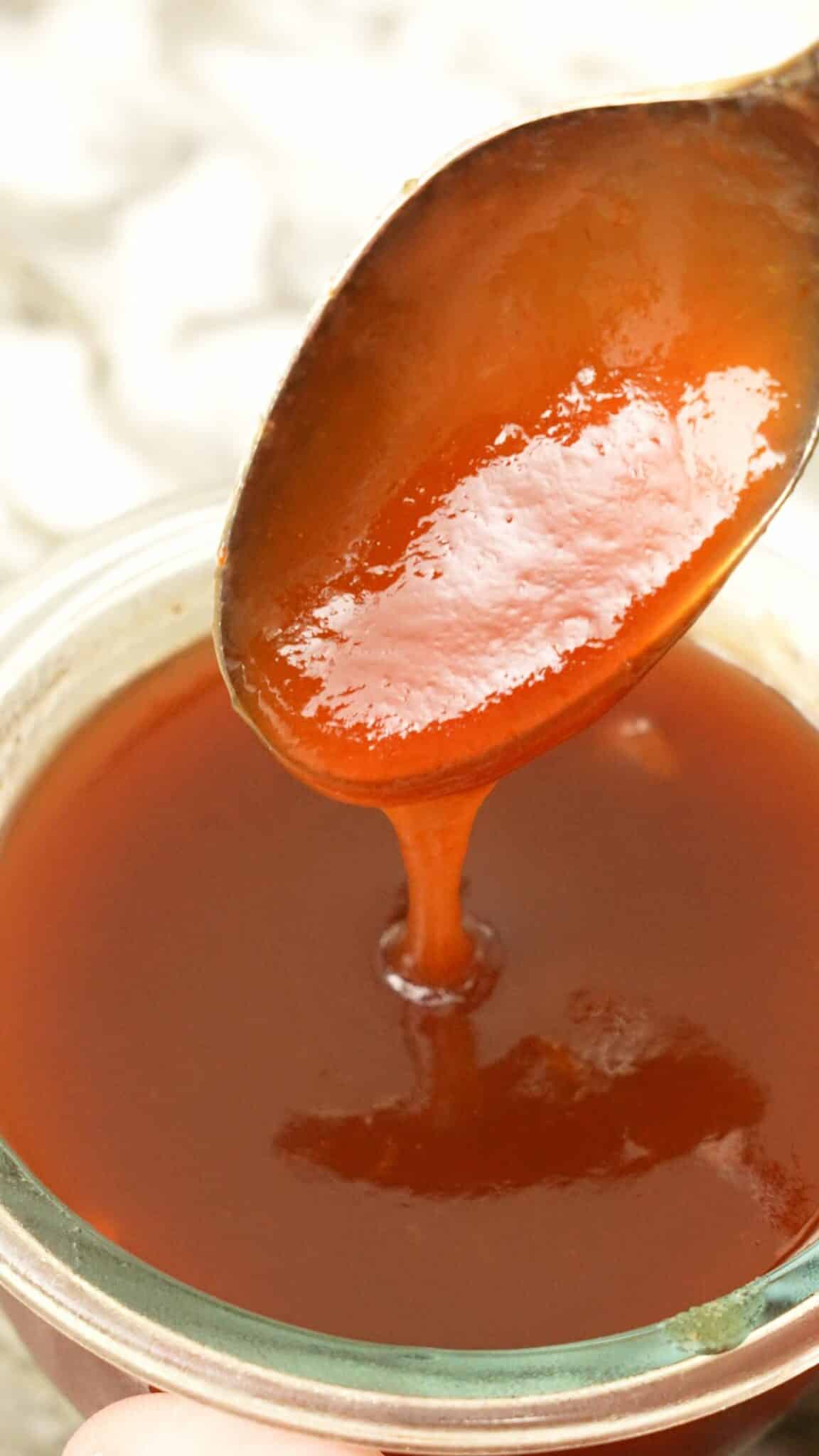 Sweet and sour sauce being spooned in a bowl.