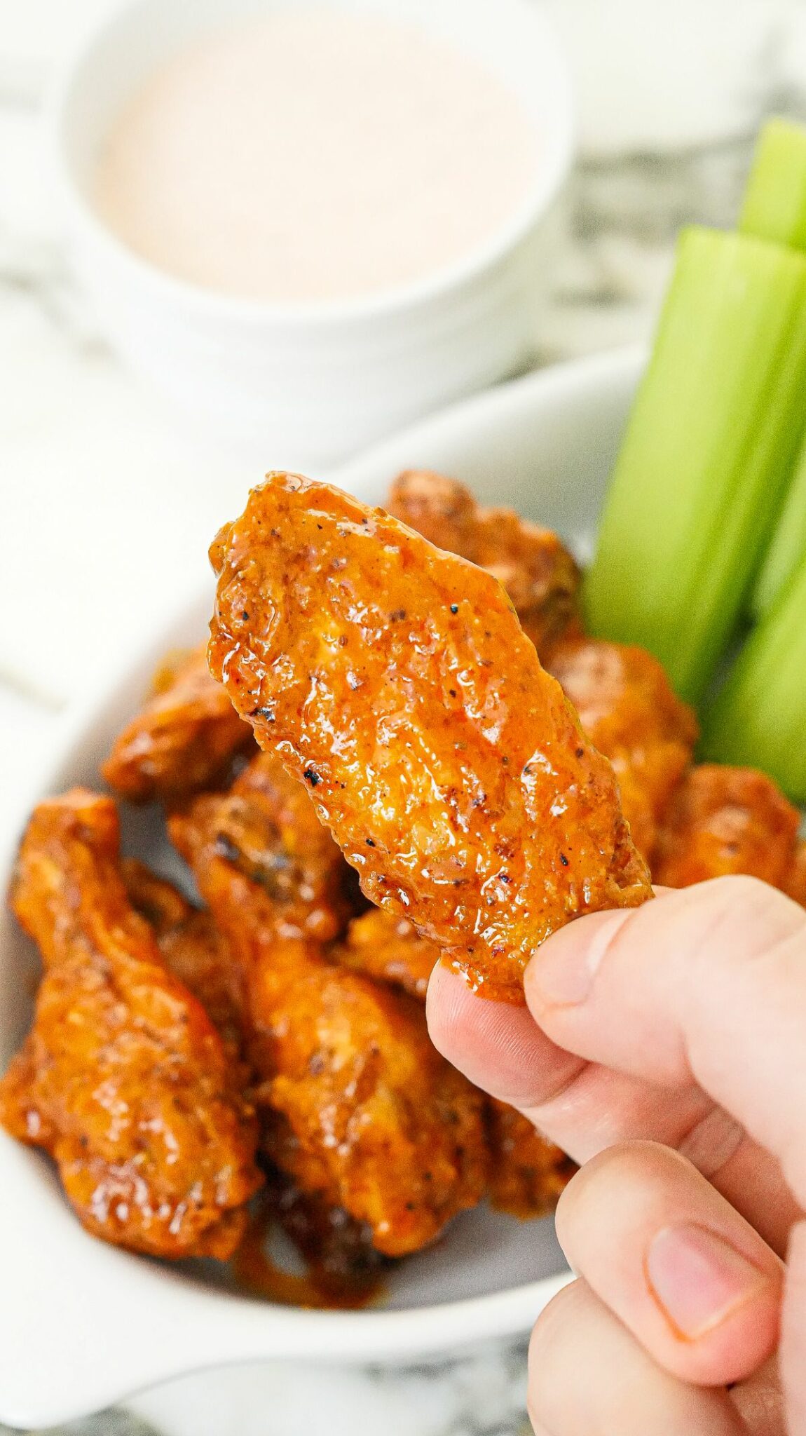 Air Fryer Buffalo Wings chicken flat held in hand.