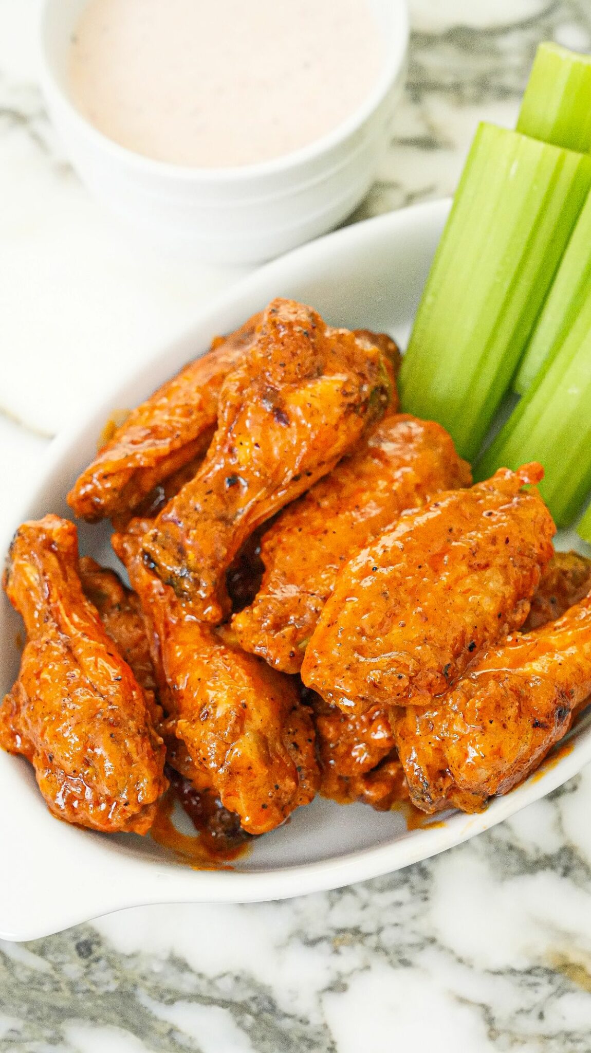 Air Fryer Buffalo Wings in a bowl with celery and ranch dressing.