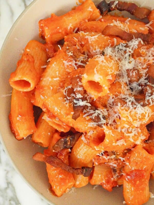 Pasta Amatriciana on a plate with guanciale, rigatoni, and pecorino cheese.