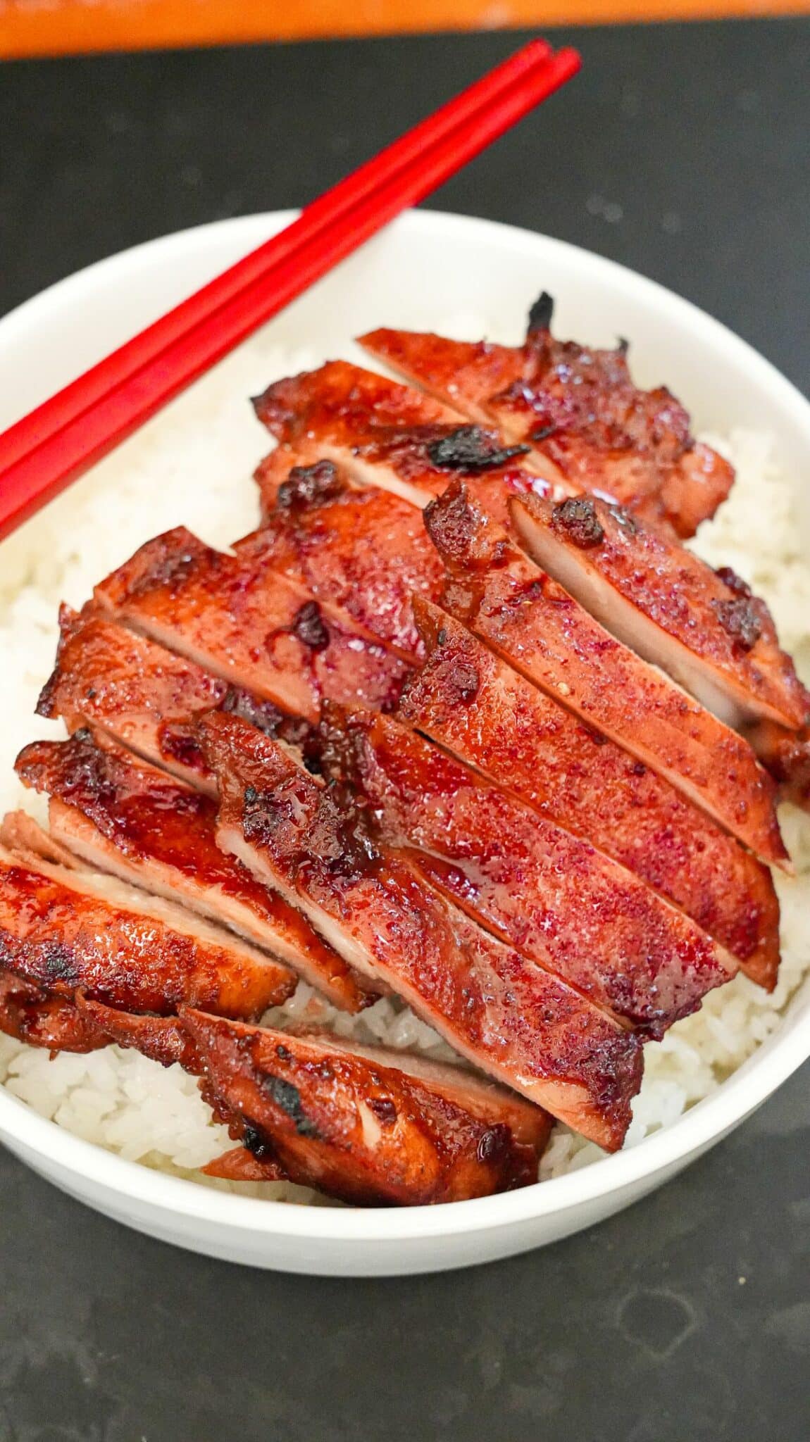 Char Siu Chicken over a plate of rice.