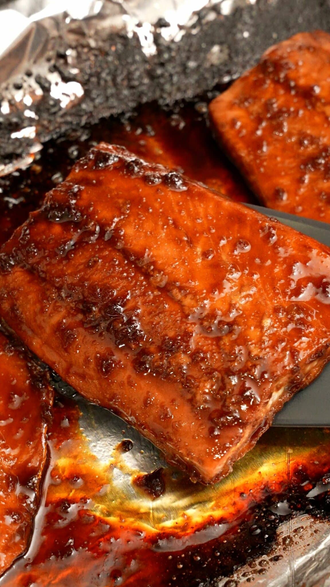 Salmon filets with the honey soy glaze broiled on a tray.