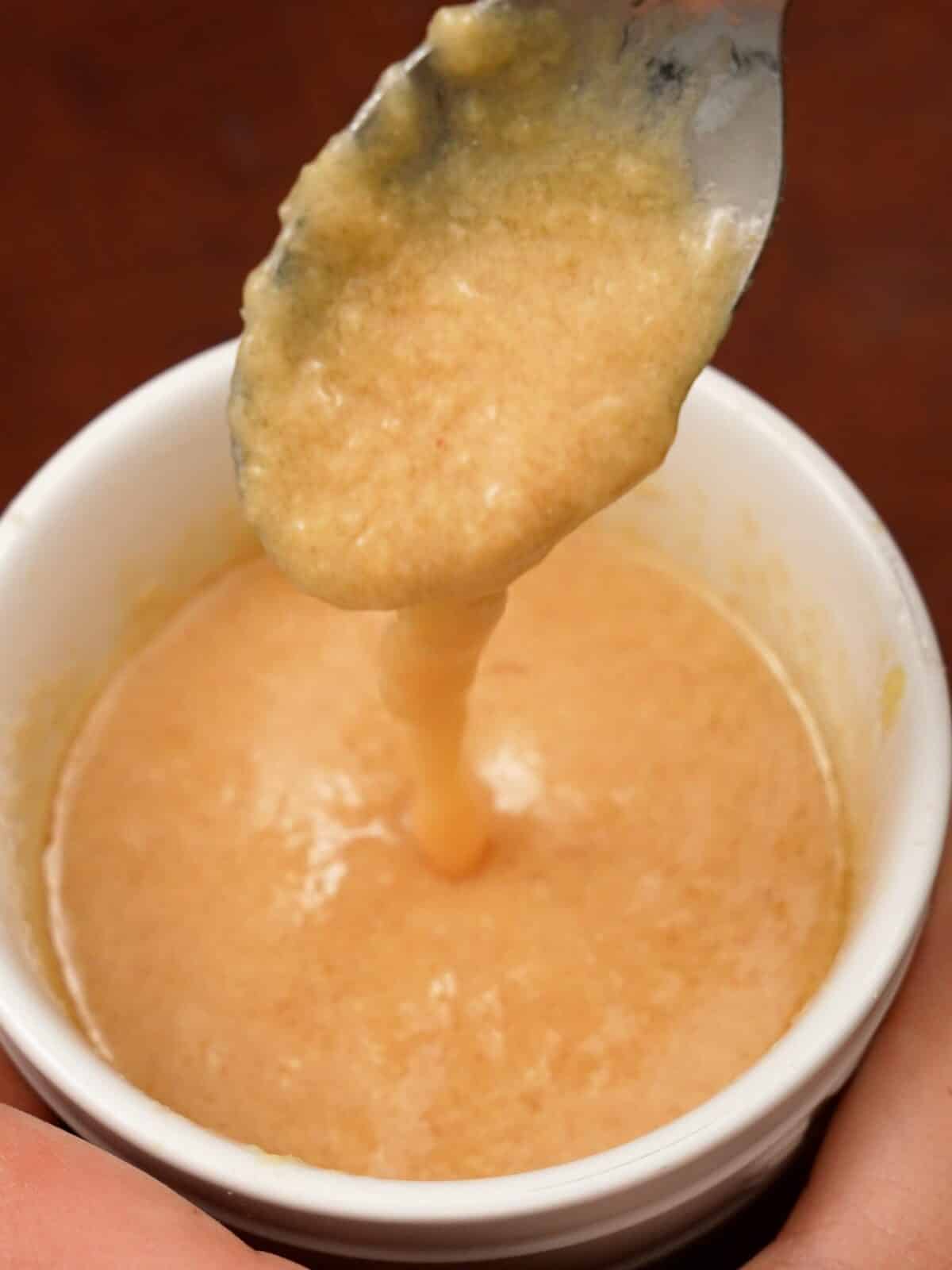 A spoon showing the miso ginger dressing.
