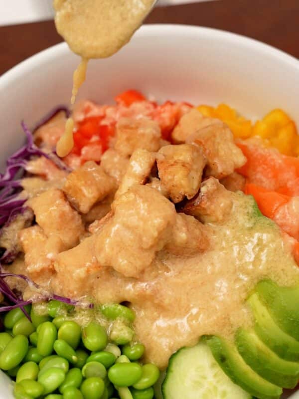 Buddha bowl with miso ginger dressing spooned on top.