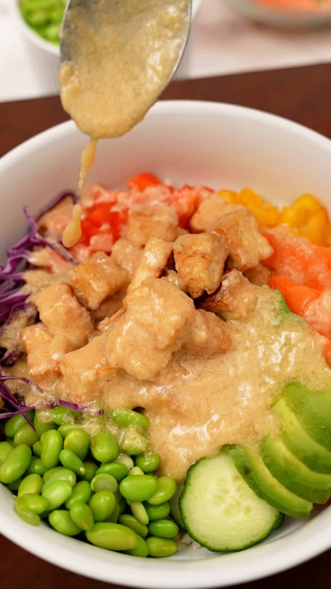 Buddha bowl with miso ginger dressing spooned on top.