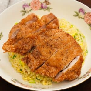 The Din Tai Fung Fried Pork Chop over the Din Tai Fung fried rice in a bowl.