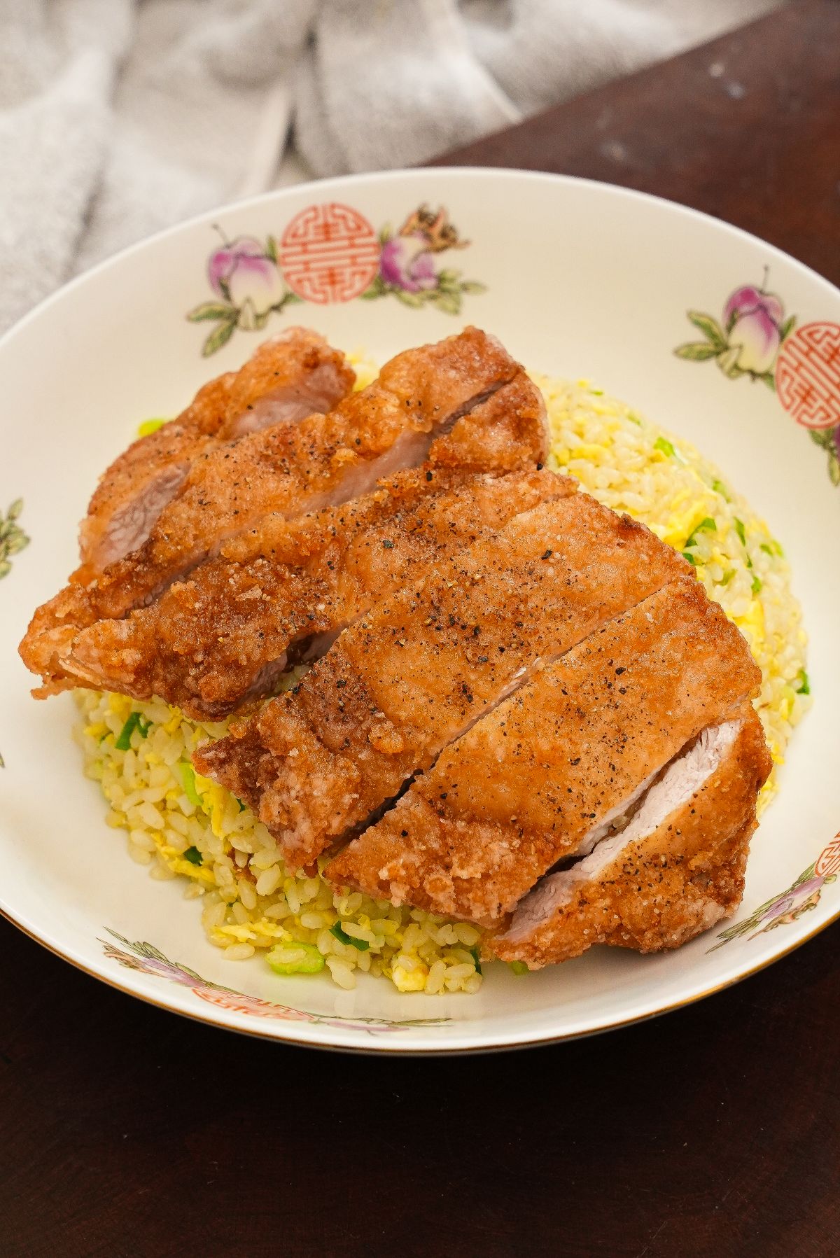 The Din Tai Fung Fried Pork Chop over the Din Tai Fung fried rice in a bowl.