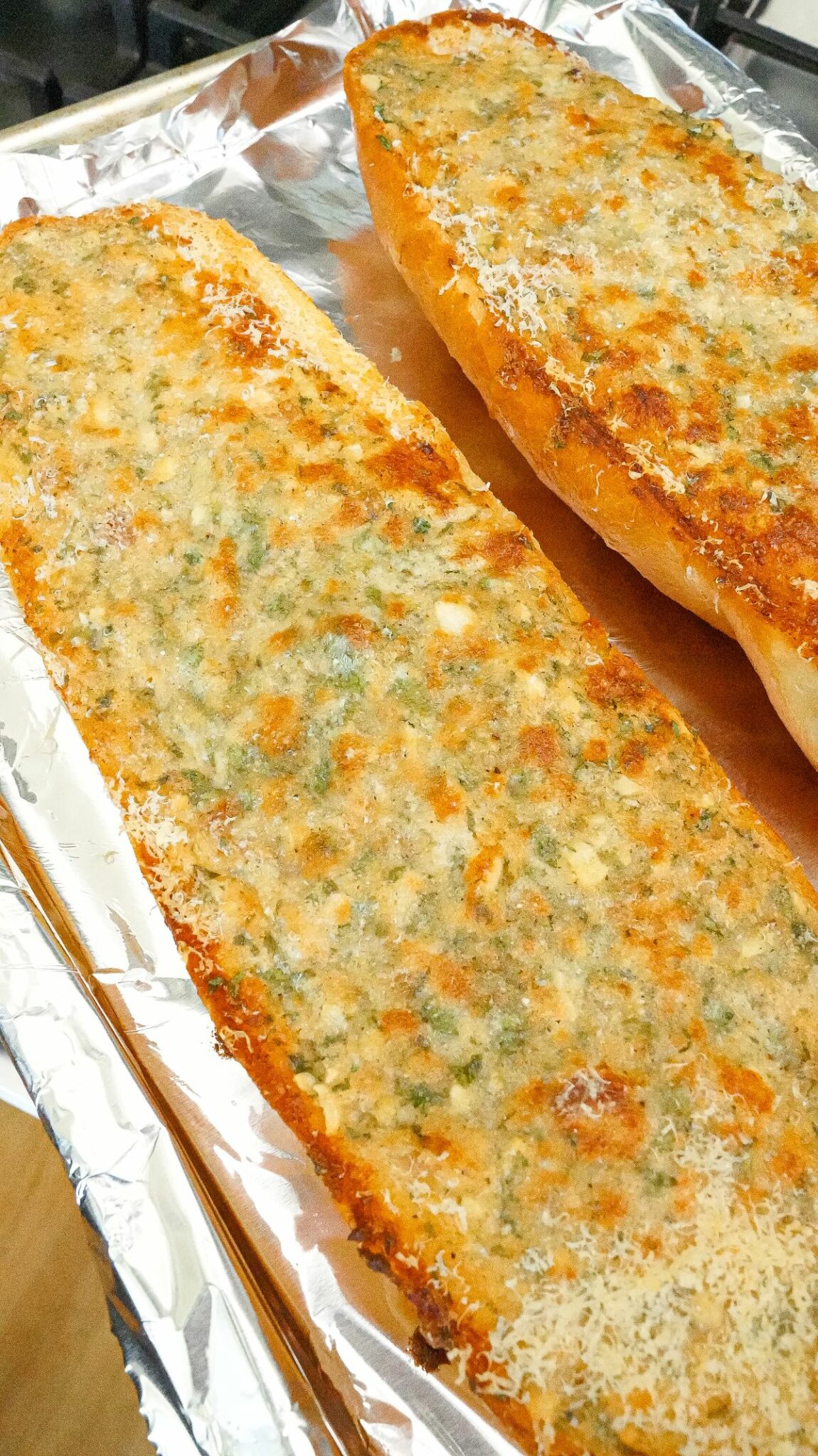 Baked garlic bread on a foil lined tray.