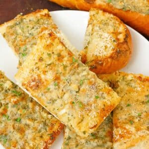 Pieces of baked garlic bread on a plate.