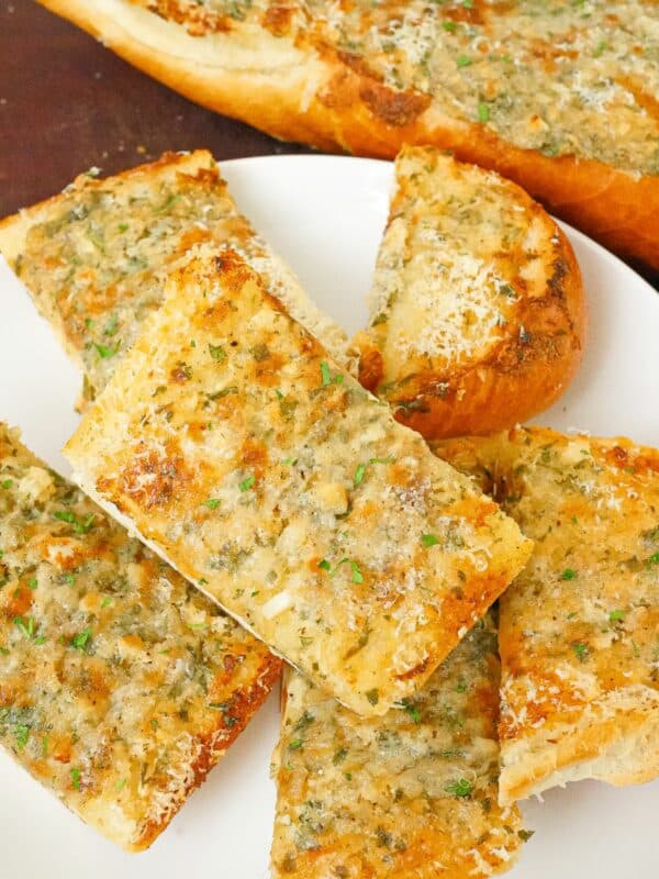 Pieces of baked garlic bread on a plate.