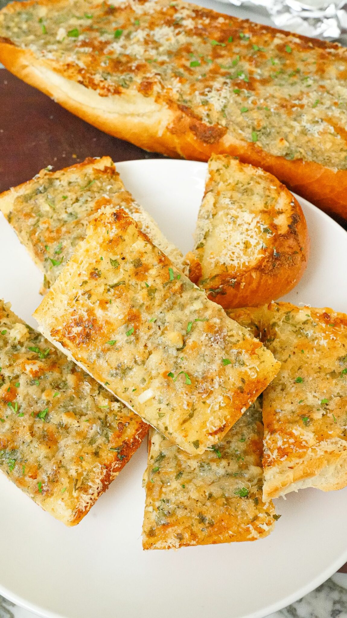 Pieces of baked garlic bread on a plate.