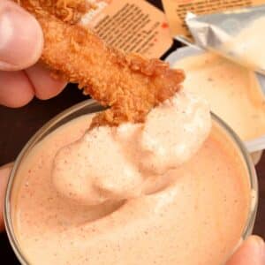Popeyes blackened ranch with chicken fingers being dipped in it.