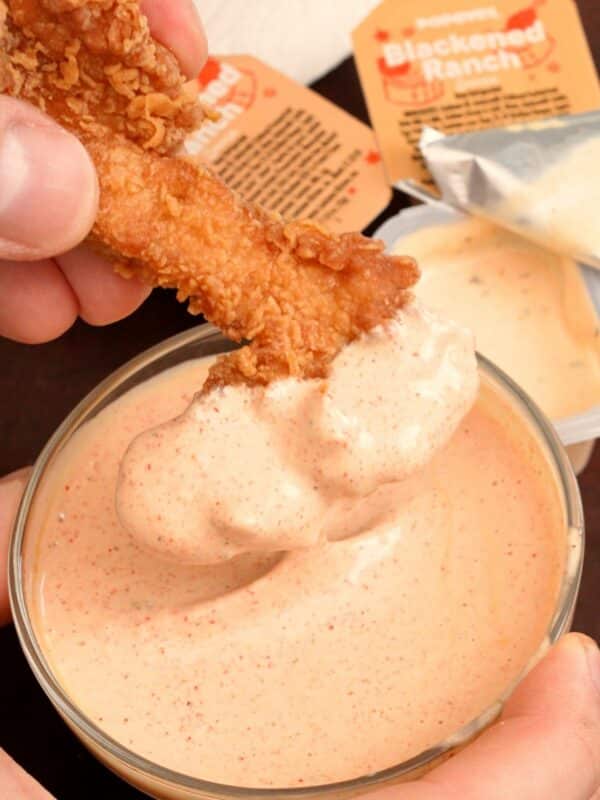 Popeyes blackened ranch with chicken fingers being dipped in it.