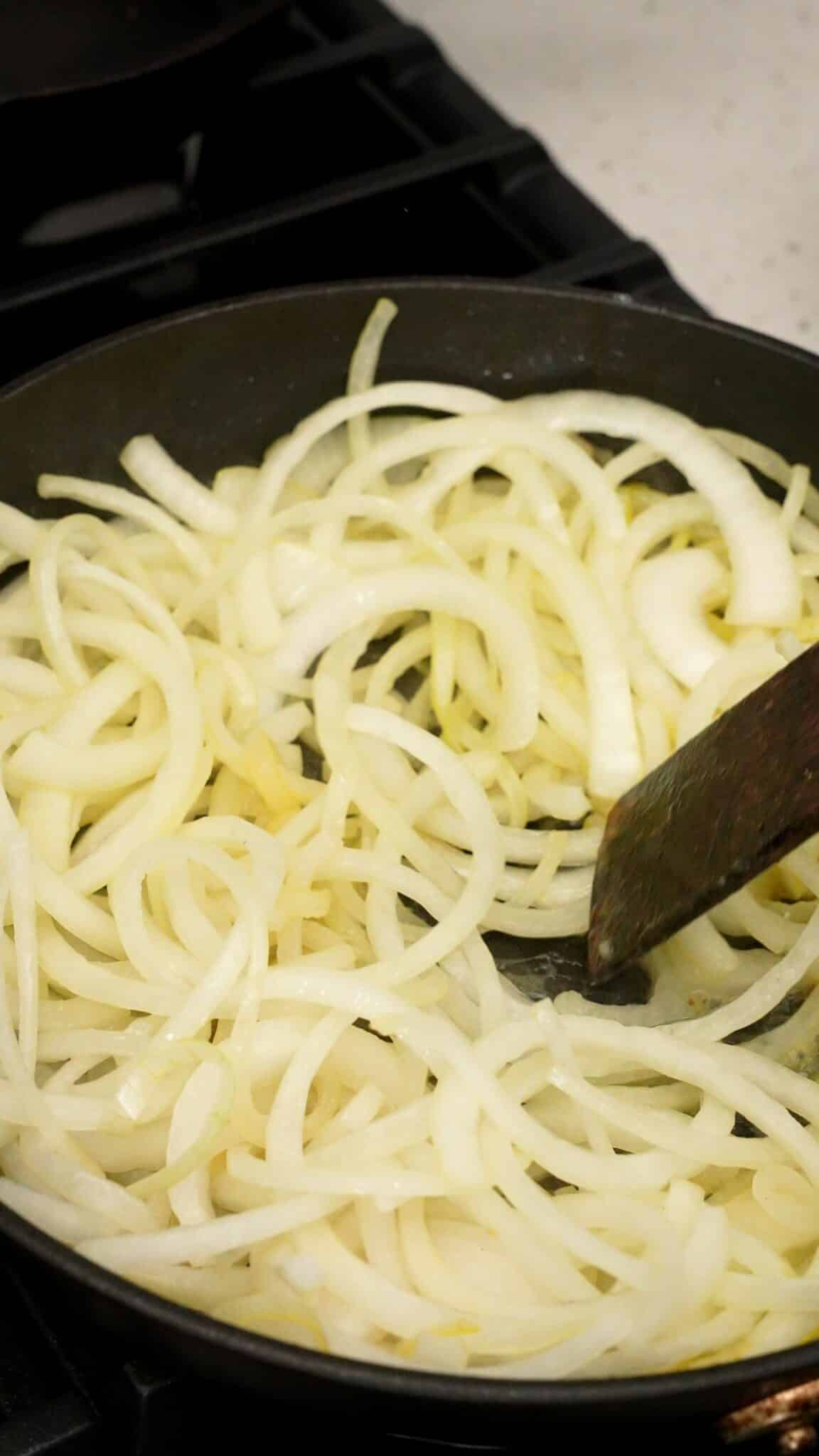 Yellow onions cooking in a pan with salt and baking soda.