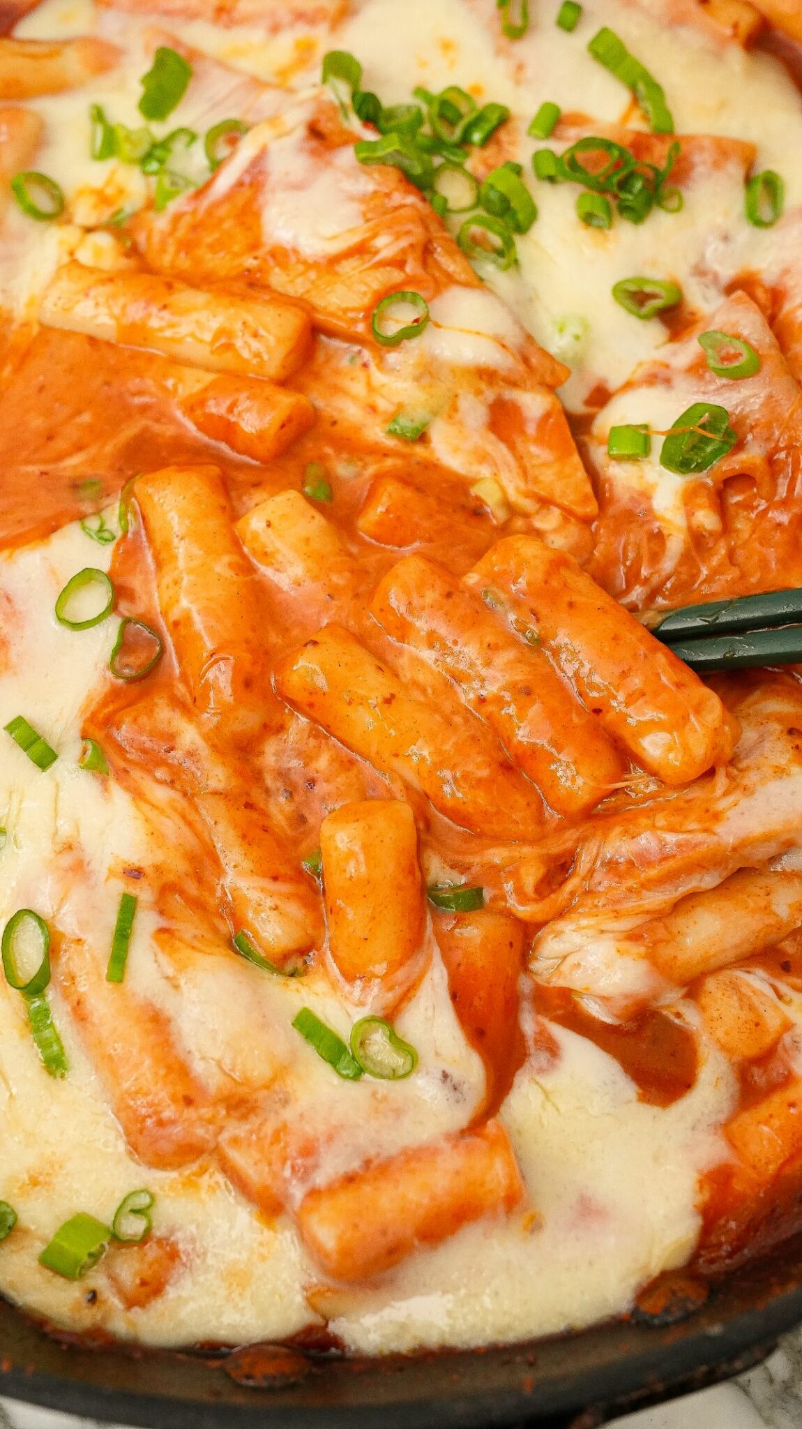 Tteokbokki in a pan with chopsticks.