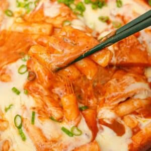 Tteokbokki in a pan with mozarella cheese.