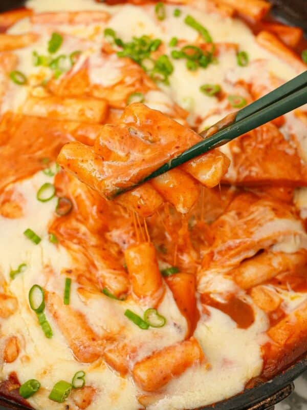 Tteokbokki in a pan with mozarella cheese.