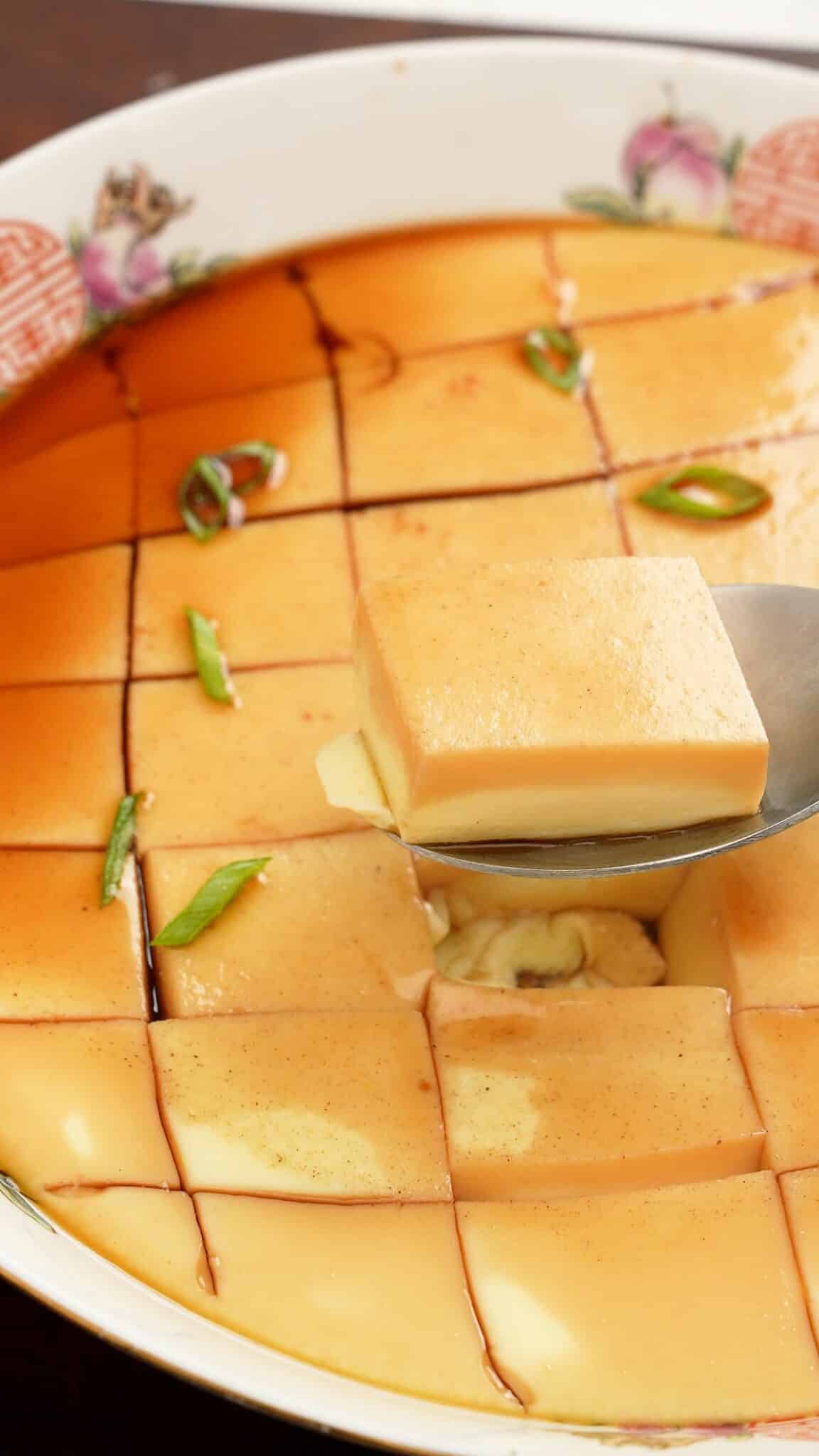 Chinese steamed eggs in a bowl with soy sauce.