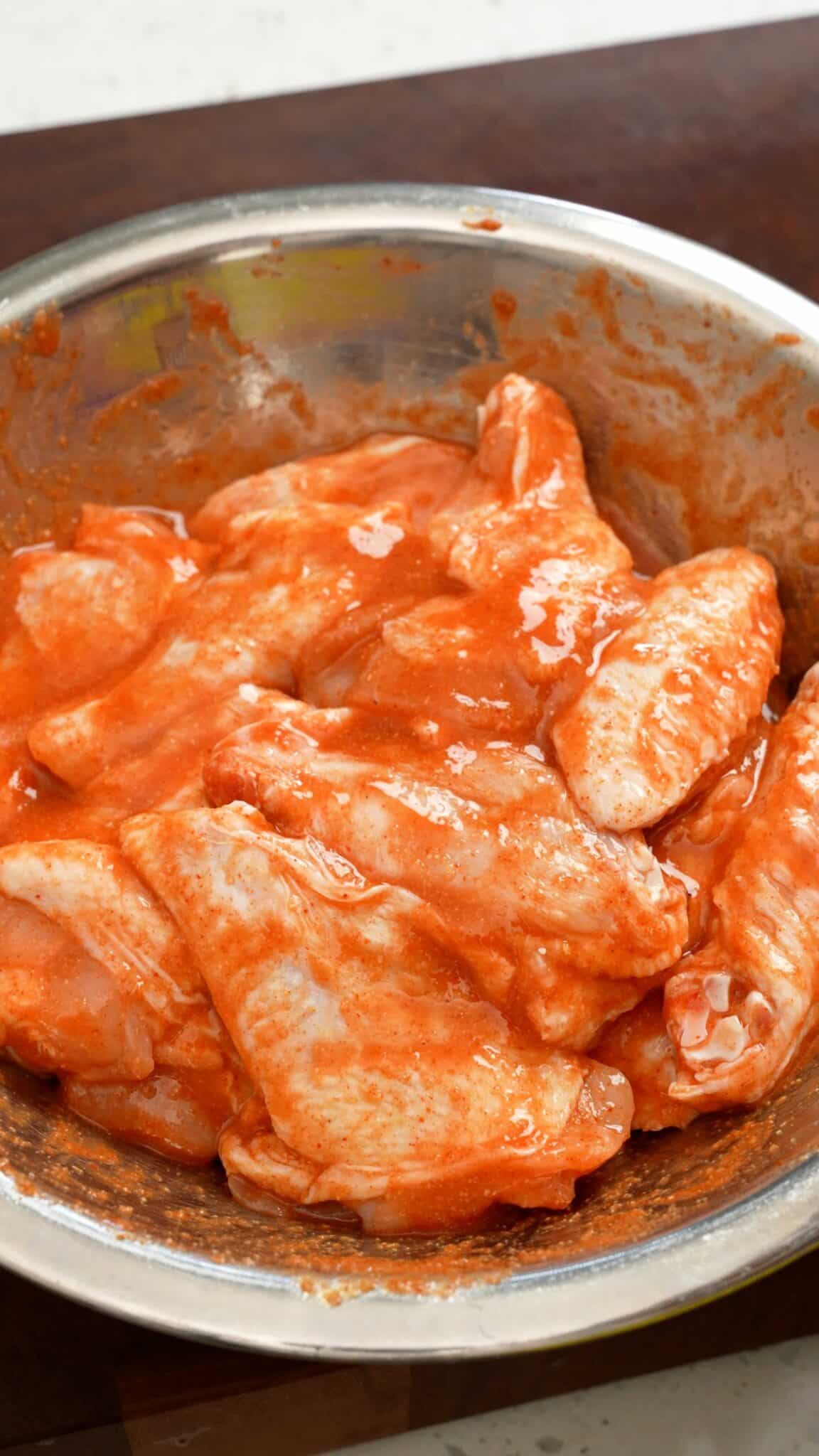 Chicken wings marinated with spices, hot sauce, and egg.