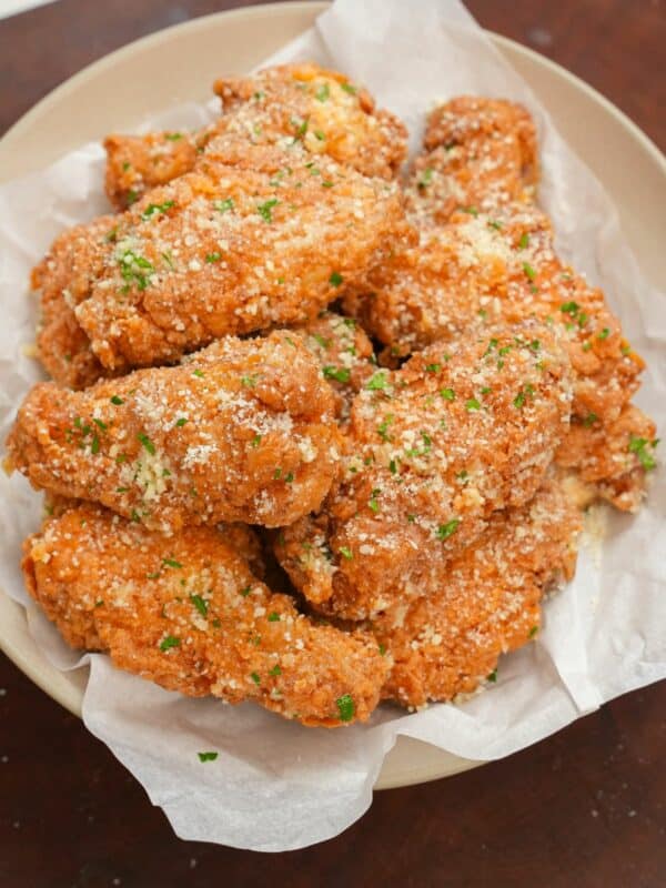 Garlic Parmesan Wings in a bowl topped with parmesan cheese and parsley.