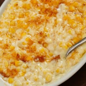 Creamed corn with sugar bruléed on top in a bowl.