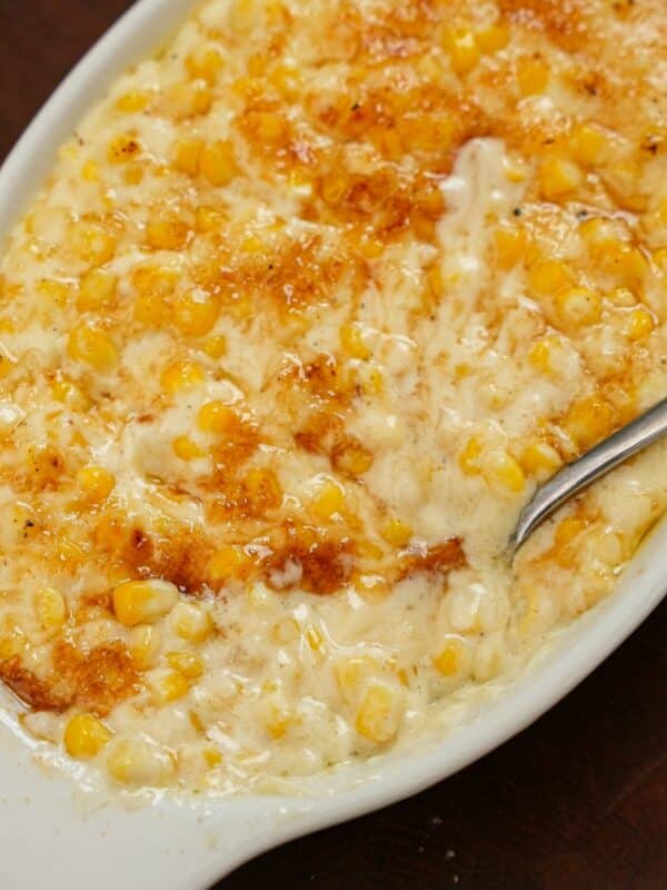 Creamed corn with sugar bruléed on top in a bowl.