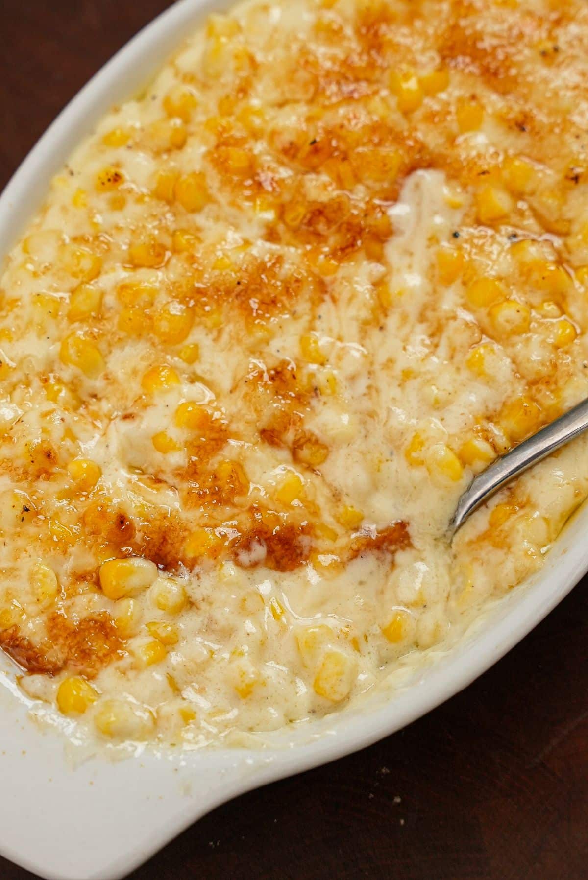 Creamed corn with sugar bruléed on top in a bowl.