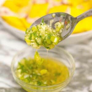 Ginger Scallion Sauce in a glass bowl with a spoon.