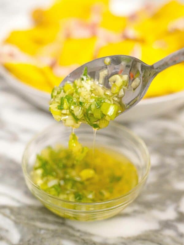 Ginger Scallion Sauce in a glass bowl with a spoon.