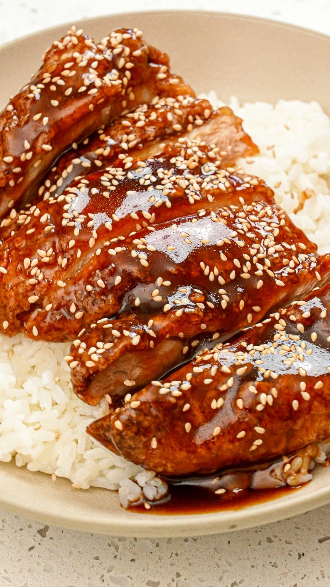 Honey Butter Chicken on a bed of rice in a bowl.
