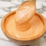Spicy mayo sauce prepared in a wooden bowl with a spoon.