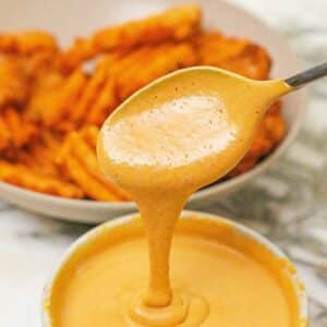 Copycat Chick-fil-a-sauce in a bowl next to a bowl of fries.