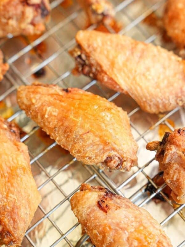 Baked Chicken wings on a wire baking rack placed on a baking sheet tray.