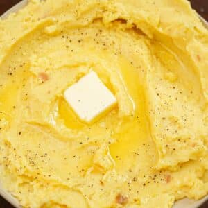 A bowl of garlic mashed potatoes with butter.