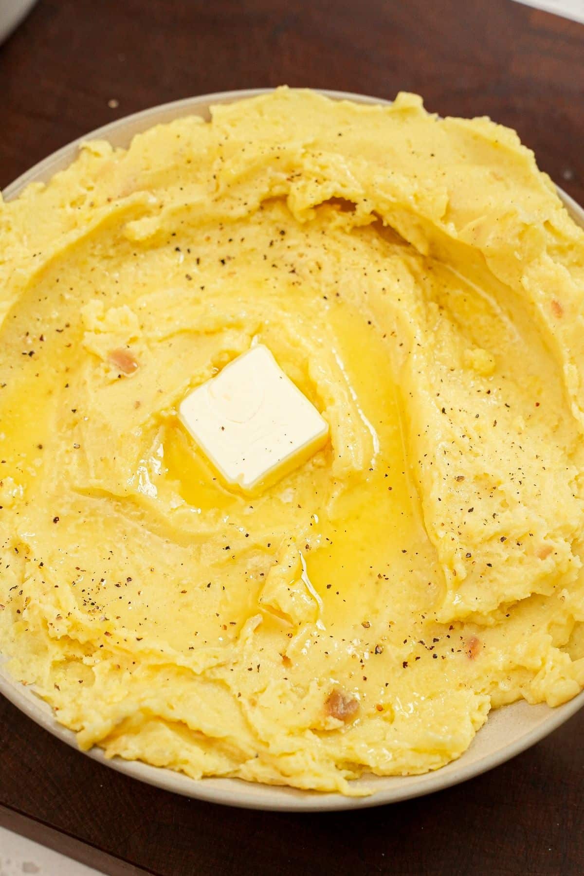 A bowl of garlic mashed potatoes with butter.