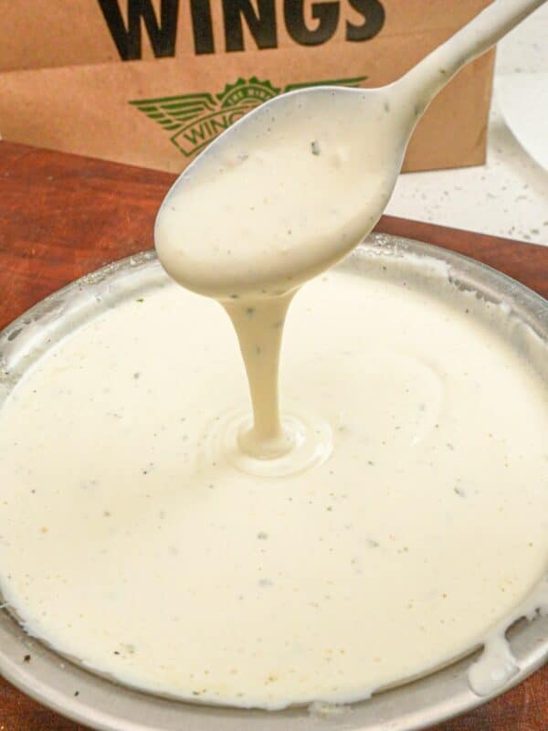 Copycat Wingstop ranch in a metal bowl in front of a wingstop paper bag.