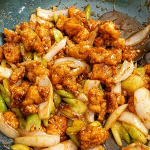 Black Pepper Tofu fried and cooked in a blue carbon steel wok.