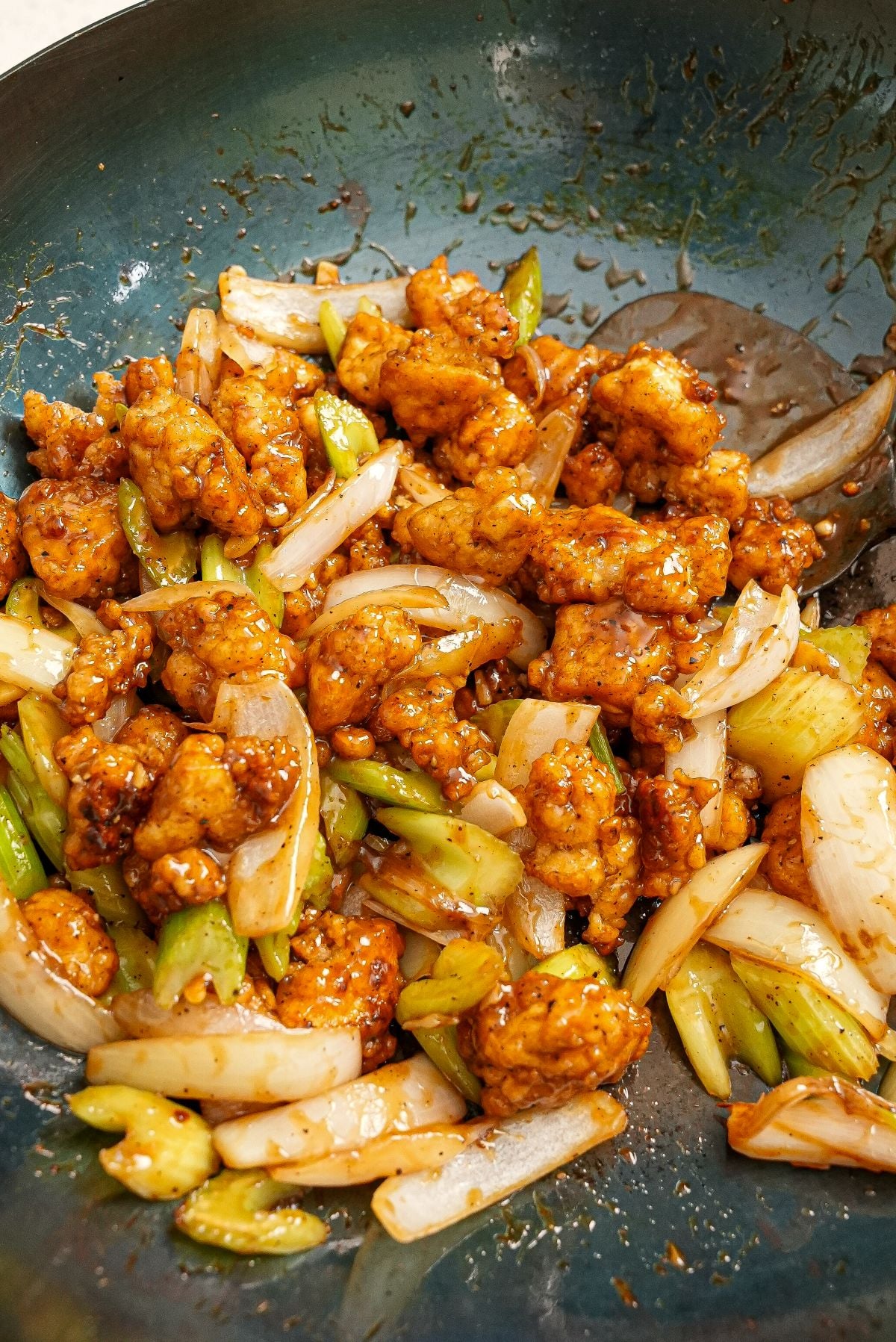 Black Pepper Tofu fried and cooked in a blue carbon steel wok.
