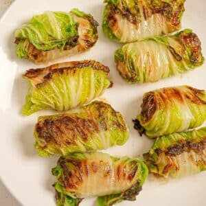 Steamed Asian cabbage rolls on a plate.