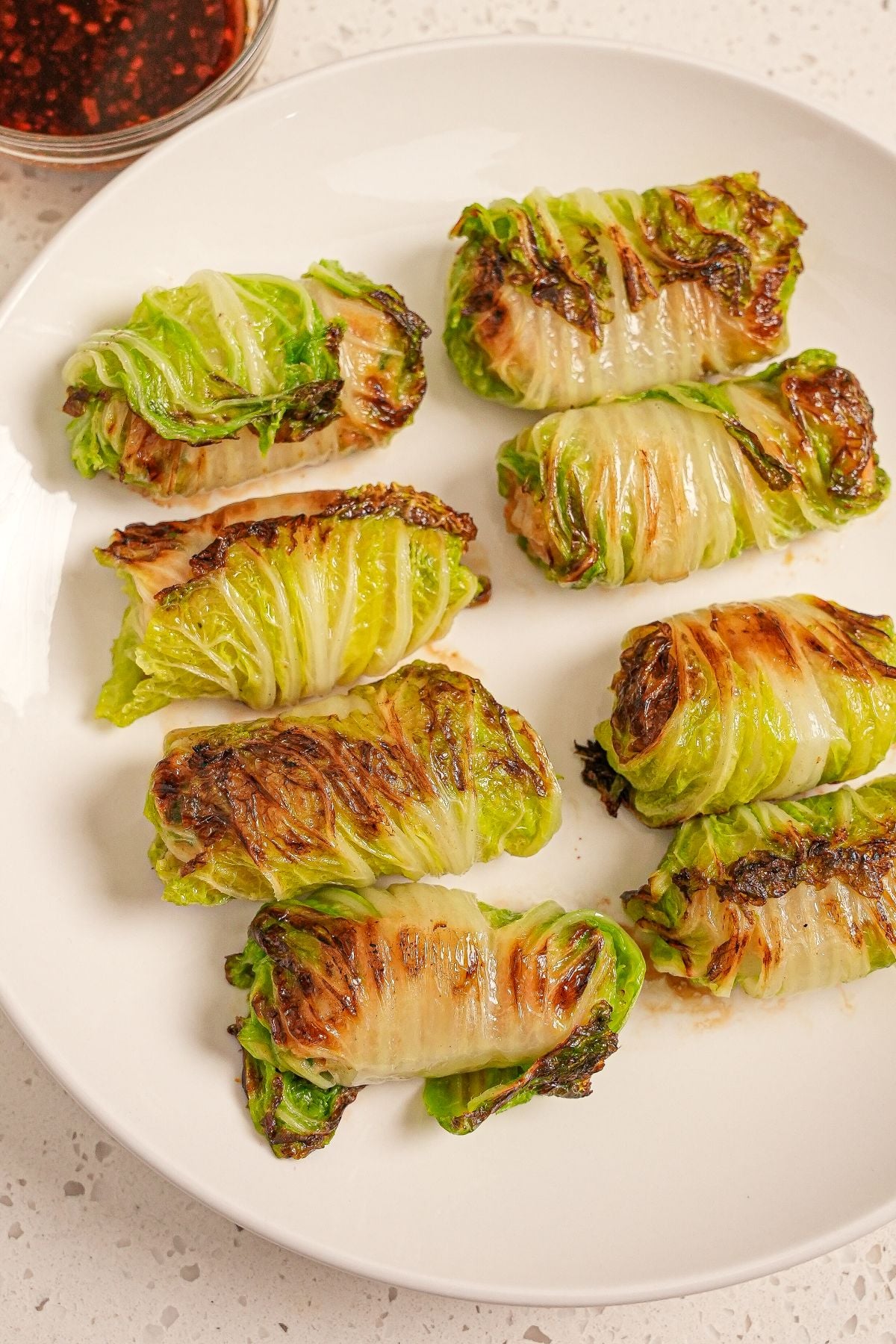 Steamed Asian cabbage rolls on a plate.
