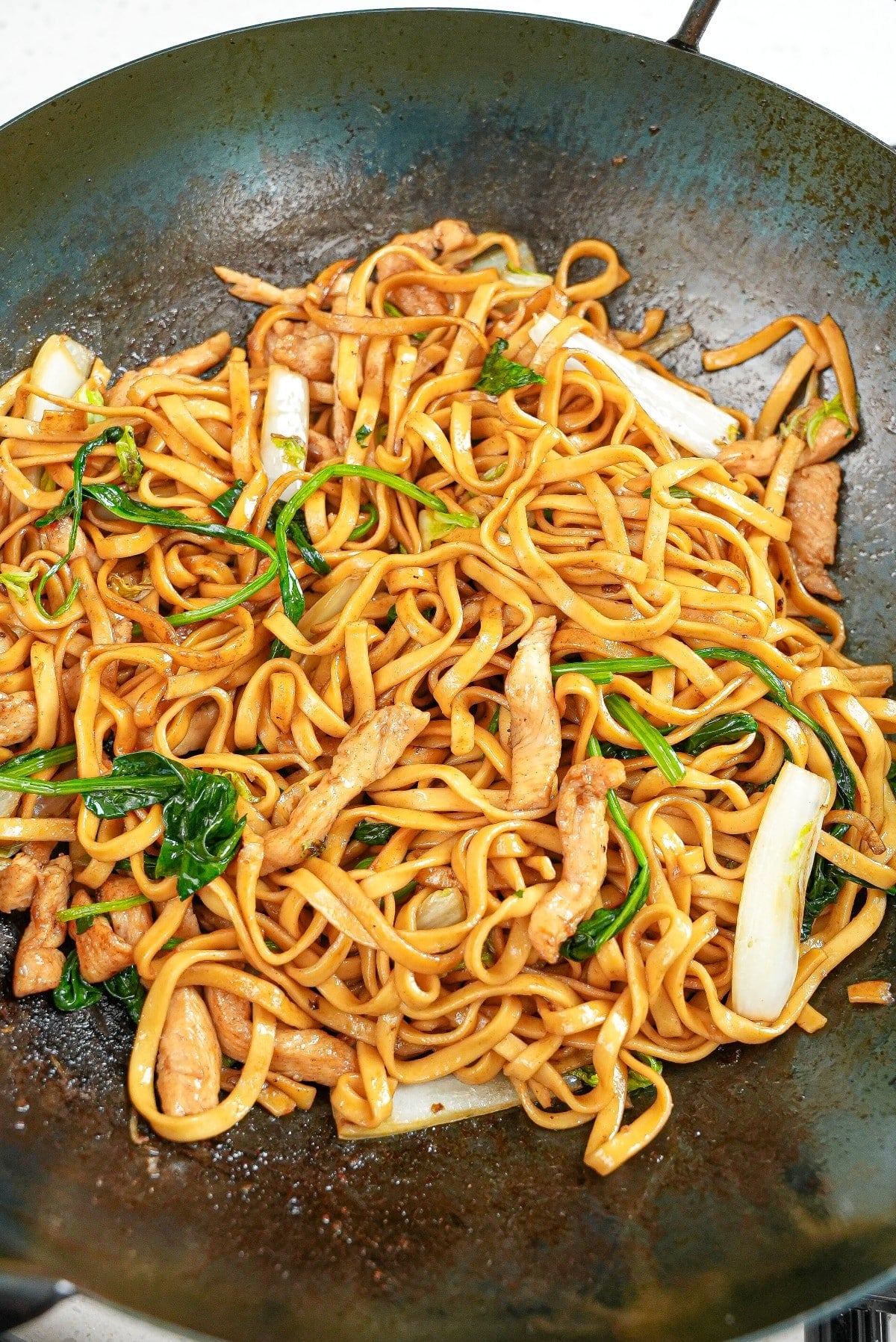 Din Tai Fried Noodles with Chicken cooked in a wok.